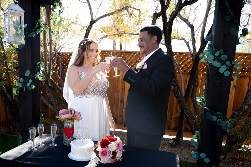 Bride and groom clinking champagne glasses during wedding toast at Mon Bel Ami Wedding Chapel in Las Vegas.